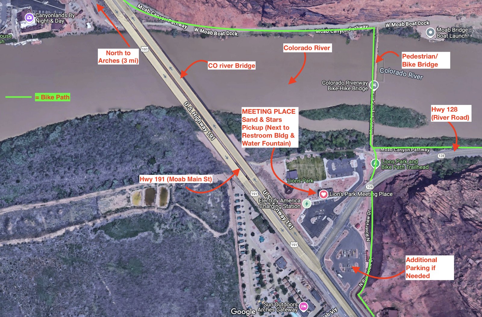Annotated satellite map of the Sand & Stars meeting place at Lion's Park, Moab — heart icon next to the restroom building and water fountain, near the Hwy 191 Colorado River bridge, with Hwy 128 (River Road), the pedestrian/bike bridge, the bike path in green, and additional parking marked.